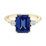 Emerald cut 3 stone engagement ring with gemstone and diamond accents.