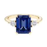 Emerald cut 3 stone engagement ring with gemstone and diamond accents.