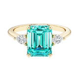 Emerald cut 3 stone engagement ring with gemstone and diamond accents.