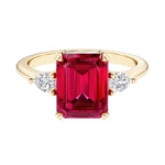Emerald cut 3 stone engagement ring with gemstone and diamond accents.