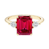 Emerald cut 3 stone engagement ring with gemstone and diamond accents.