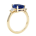 Emerald cut 3 diamond ring representing past, present, and future featuring blue gemstone center.