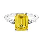 Three stone emerald cut engagement ring for timeless elegance featuring pink gemstone and diamonds.