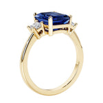 Emerald cut 3 diamond ring representing past, present, and future featuring blue gemstone center.