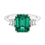 Three stone emerald cut engagement ring for timeless elegance featuring green gemstone and diamonds.
