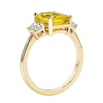 Emerald cut 3 diamond ring representing past, present, and future featuring yellow gemstone center.