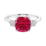 Cushion shaped engagement ring with brilliant diamonds and red gemstone.