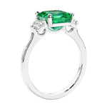 Asscher shaped ring in a timeless three stone ring set with diamond sides and colombian emerald center.