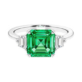 Asscher gemstone diamond ring with step-cut sparkle in a three stone setting featuring colombian emerald center.