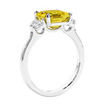 Asscher shaped ring in a timeless three stone ring set with diamond sides and yellow sapphire center.