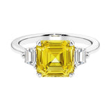 Asscher gemstone diamond ring with step-cut sparkle in a three stone setting featuring yellow sapphire center.