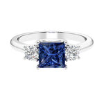 3 stone princess diamond ring in sleek white gold with blue sapphire gemstone.