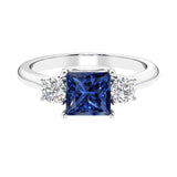 3 stone princess diamond ring in sleek white gold with blue sapphire gemstone.