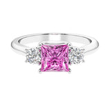 3 stone princess diamond ring in sleek white gold with pink sapphire gemstone.