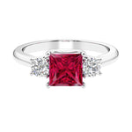 3 stone princess diamond ring in sleek white gold with ruby gemstone.