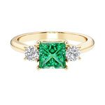 Princess cut 3 stone engagement ring with side diamonds and colombian emerald gemstone center.