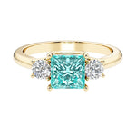 Princess cut 3 stone engagement ring with side diamonds and paraiba tourmaline gemstone center.
