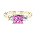 Princess cut 3 stone engagement ring with side diamonds and pink sapphire gemstone center.