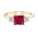 Princess cut 3 stone engagement ring with side diamonds and ruby gemstone center.