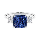 3 stone princess diamond ring in sleek white gold with blue sapphire gemstone center.