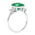 Engagement ring with princess cut diamonds in a 3 stone design featuring colombian emerald gemstone center.