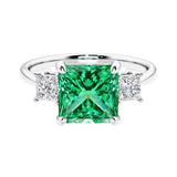 3 stone princess diamond ring in sleek white gold with colombian emerald gemstone center.