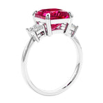 Engagement ring with princess cut diamonds in a 3 stone design featuring ruby gemstone center.