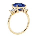 Elegant three stone princess cut engagement ring with blue sapphire and diamonds.