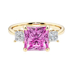 Princess cut 3 stone engagement ring with square side diamonds and pink sapphire gemstone center.