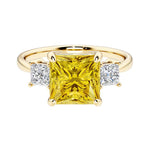 Princess cut 3 stone engagement ring with square side diamonds and yellow sapphire gemstone center.