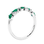 Women’s anniversary ring with lab created green emerald and sparkling round diamonds in a vintage-inspired half eternity style.