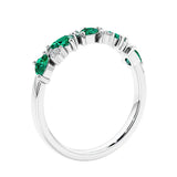 Women’s anniversary ring with lab created green emerald and sparkling round diamonds in a vintage-inspired half eternity style.