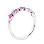 Women’s anniversary ring with lab created pink sapphire and sparkling round diamonds in a vintage-inspired half eternity style.