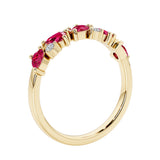 Unique 9 stone half eternity ring with pear shaped ruby and round diamond accents in yellow gold.