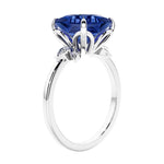 Women's unique ring with lab created blue sapphire and sparkling round diamonds in a vintage-inspired cluster side stone style.