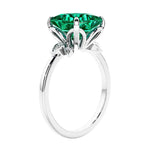 Women's unique ring with lab created green emerald and sparkling round diamonds in a vintage-inspired cluster side stone style.