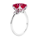 Women's unique ring with lab created ruby and sparkling round diamonds in a vintage-inspired cluster side stone style.