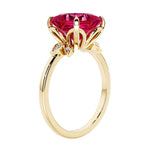 Unique nature inspired ring with princess cut ruby and round diamond accents in yellow gold.