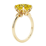 Unique nature inspired ring with princess cut yellow sapphire and round diamond accents in yellow gold.