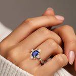 Woman wearing oval cut sapphire and diamond vintage engagement ring.