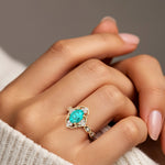 Woman wearing oval cut paraiba tourmaline and diamond vintage engagement ring.