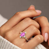 Woman wearing oval cut pink sapphire and diamond vintage engagement ring.