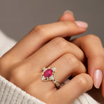 Woman wearing oval cut ruby and diamond vintage engagement ring.