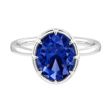 Blue sapphire oval solitaire bezel ring in 14K white gold with tapered band by Pel & Co – deep royal blue natural sapphire engagement ring