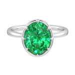 Pel & Co oval Colombian emerald solitaire ring in white gold bezel setting with tapered band – vivid green emerald engagement ring