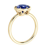 Deep blue oval sapphire solitaire bezel ring with tapered yelllow gold band by Pel & Co – elegant sapphire engagement ring