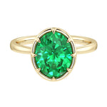 Elegant Colombian emerald engagement ring with oval emerald center stone in bezel setting and tapered yellow gold band by Pel & Co