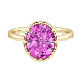 Oval pink sapphire solitaire bezel ring in 14K yellow gold with tapered band by Pel & Co – elegant pink sapphire engagement ring