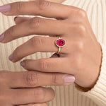 Pel & Co ruby solitaire ring with oval ruby center stone in sleek bezel setting and tapered gold band