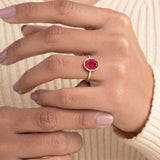 Pel & Co ruby solitaire ring with oval ruby center stone in sleek bezel setting and tapered gold band